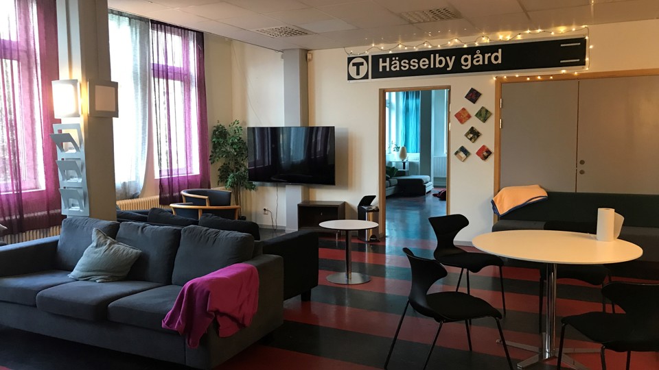 Soffgrupper, stolar, och bord. En TV hänger på väggen.