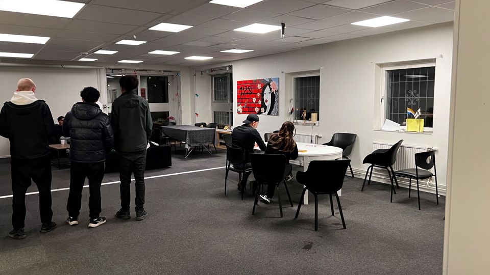 Ett stort rum med ungdomar som sitter och står utspridda i lokalen.