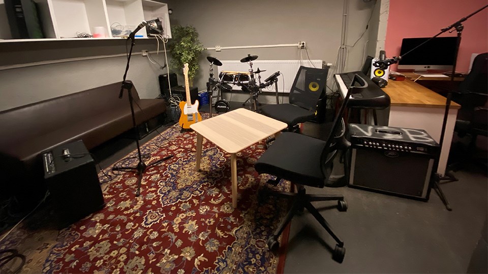 Musikstudio med instrument, förstärkare och mikrofoner.