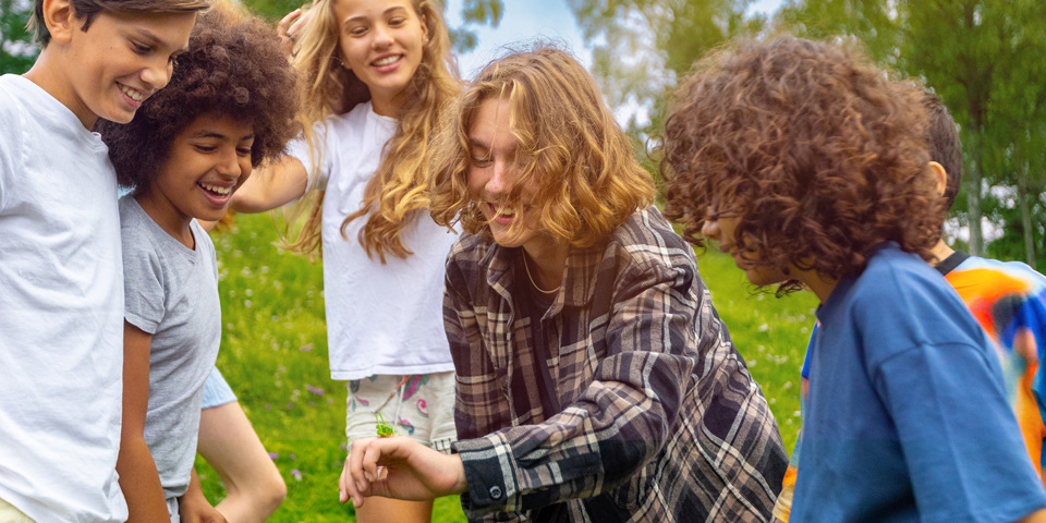 Barn som umgås och tittar på en gräshoppa.