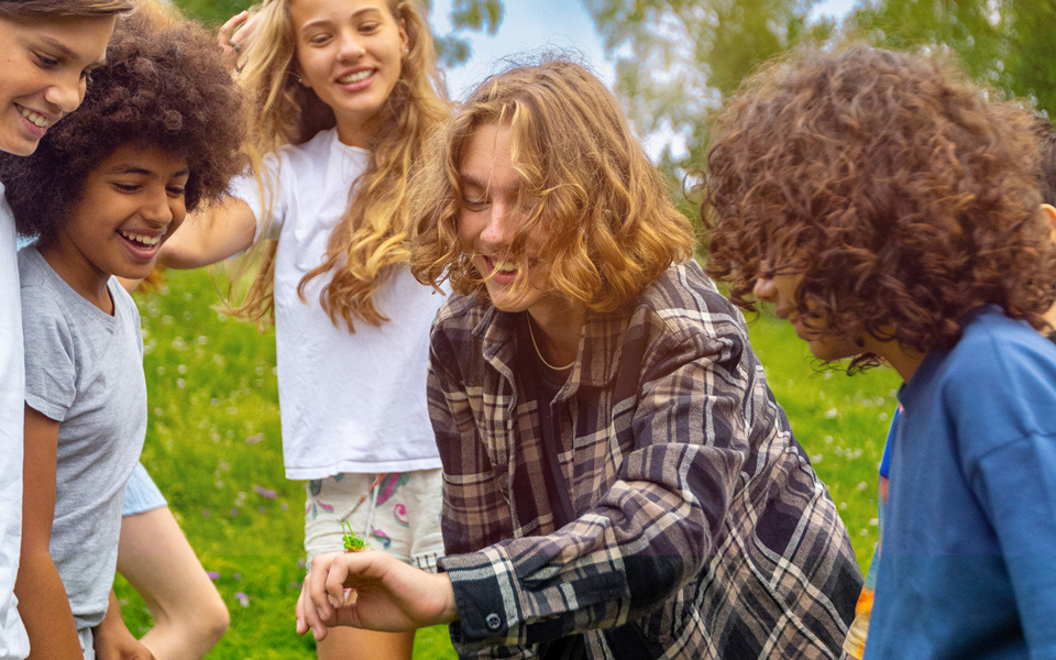 Barn som umgås och tittar på en gräshoppa.